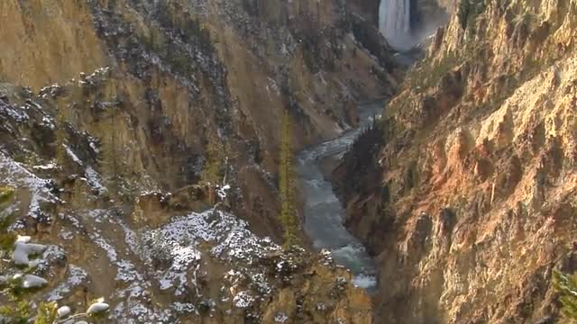 A waterfall flows down a mountainside in Yellowstone National Park.