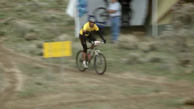 A cyclist races through rough terrain.