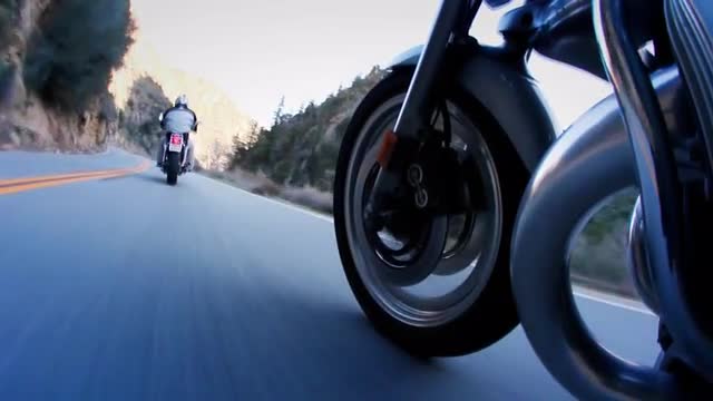 Motorcyclists are riding down a mountain highway.
