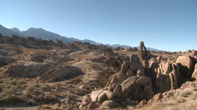 Pan across the granite rock formations of the Alabama Hills and the Sierra Nevada Range above Lone P