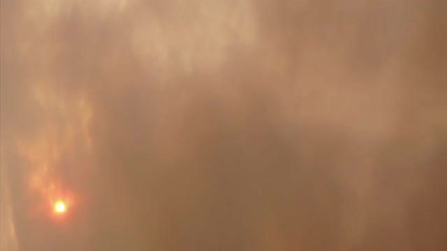 Blowing smoke obscures sunlight.
