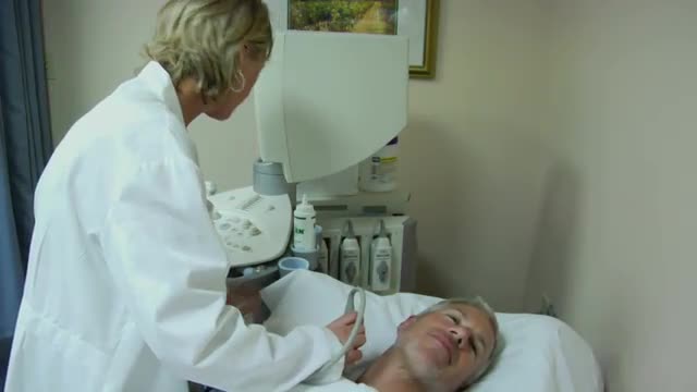 A technician uses an ultrasound machine on a patient.