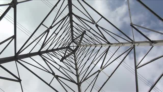 Wires stretch to either side of a utility tower.