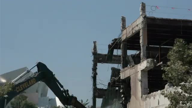 A construction bulldozer destroys a building in time lapse.