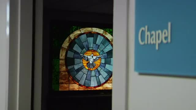 A stained glass window beautifies a hospital chapel.