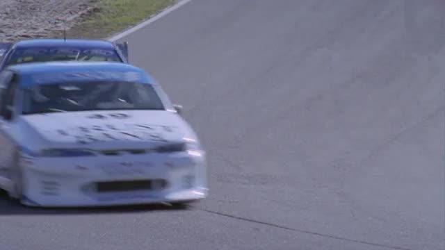 Racing cars competing on a circuit track.
