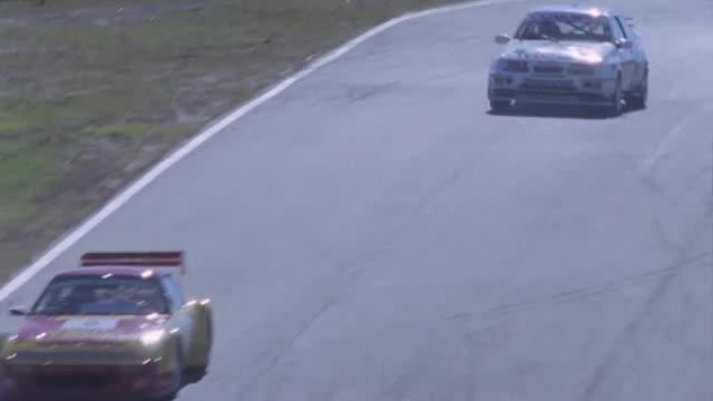 Racing cars competing on a circuit track.