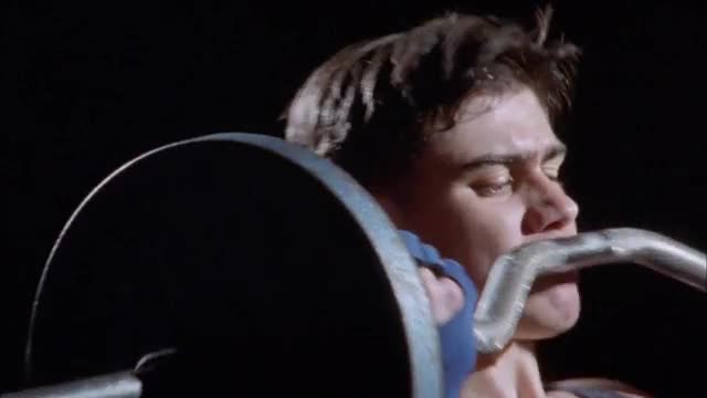 A young man does a barbell workout.