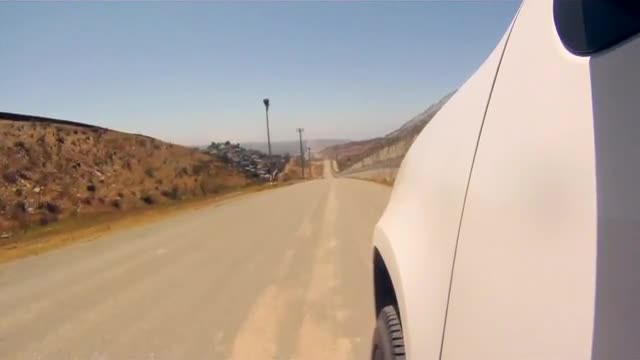 POV shot as a border patrol vehicle moves along a dirt road on the U.S. Mexican border.
