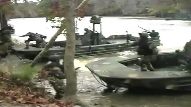 Navy SEALS special ops warcraft practice a river invasion exercise.