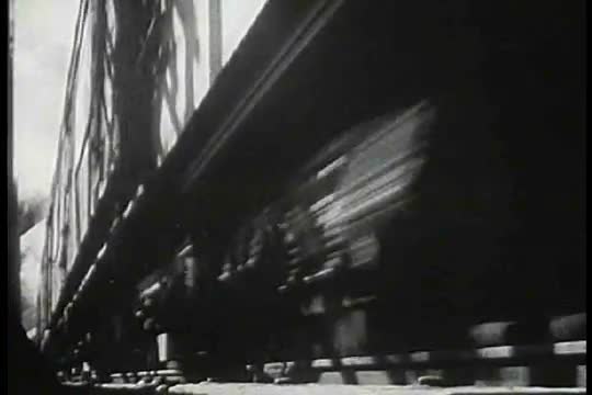 A speeding steam train passes by the camera.
