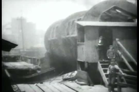 Shows how a full carload of coal is loaded into a vessel every thirty seconds at the great Erie Rail