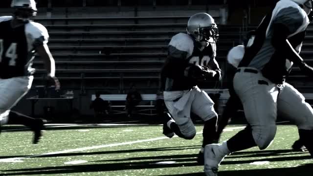 Football players line up, and and running back runs the ball for a big gain