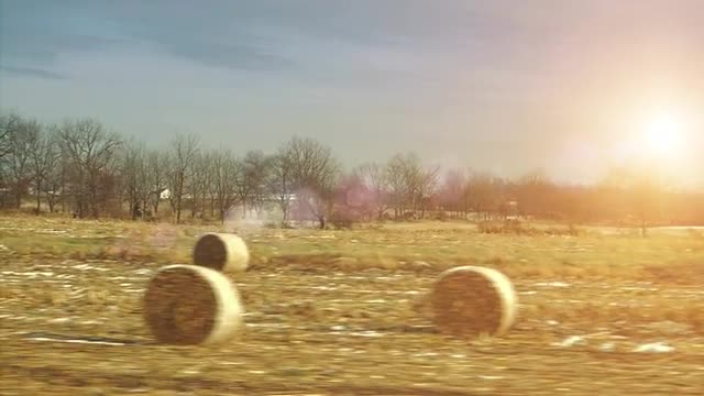 Sunny Hay Bails shot from a Car passing fields in Slow motion