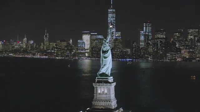 WIDE AERIAL TO CLOSE UP of Statue of Liberty and Downtown NYC 
