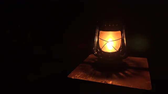 Oil lamp lit in the darkness. 4K.