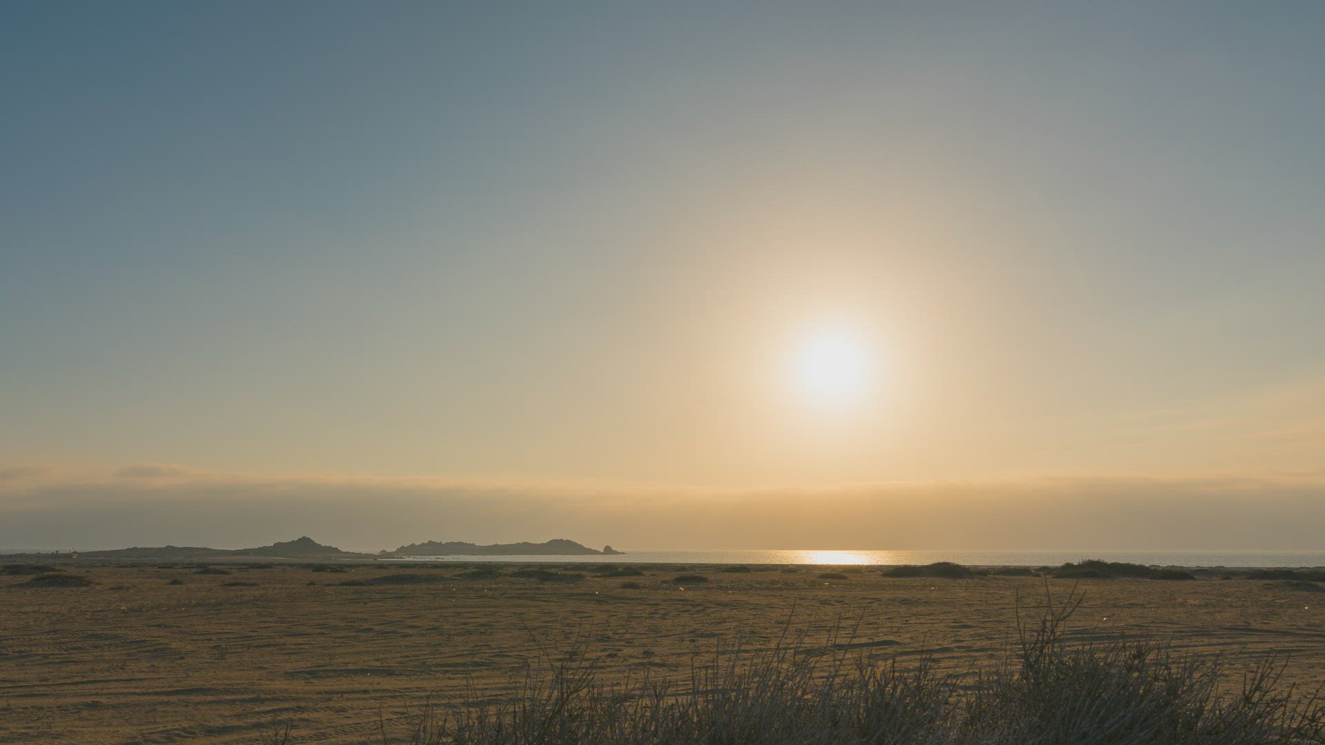 Timelapse of the sun setting over a desert, showing beautiful golden colours.