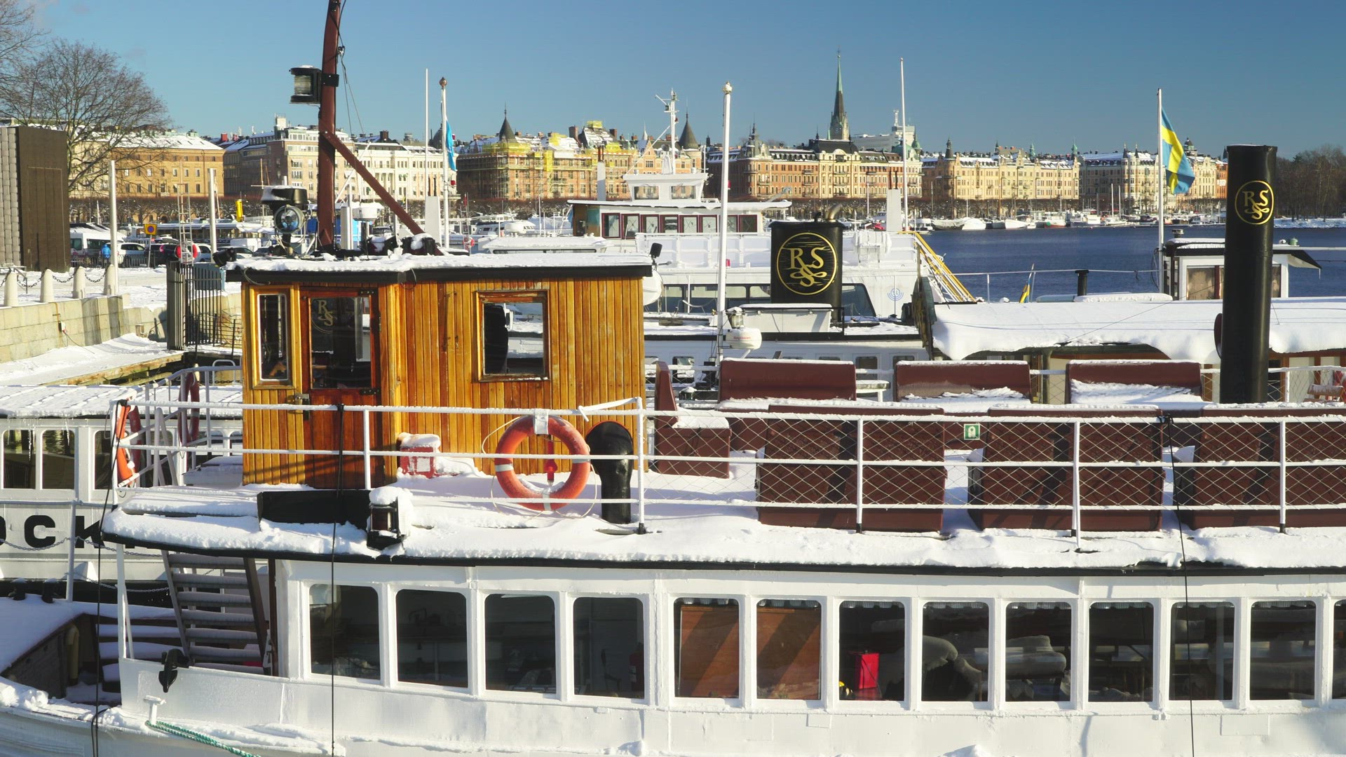 boats covered in snow at quay in Stockholm