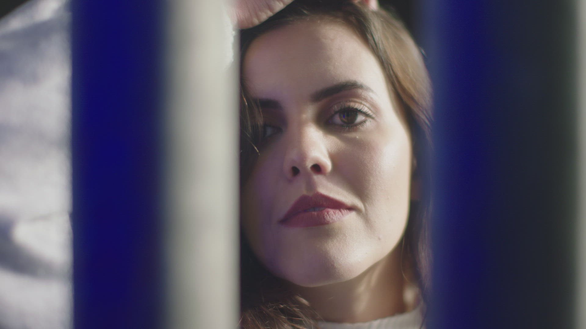 Portrait of woman looking through bars, London, UK