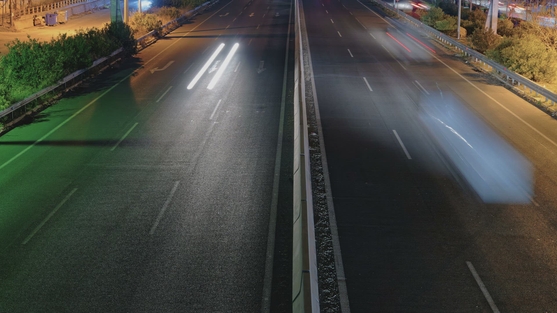 Elevated traffic time lapse on a highway separated by a median. 