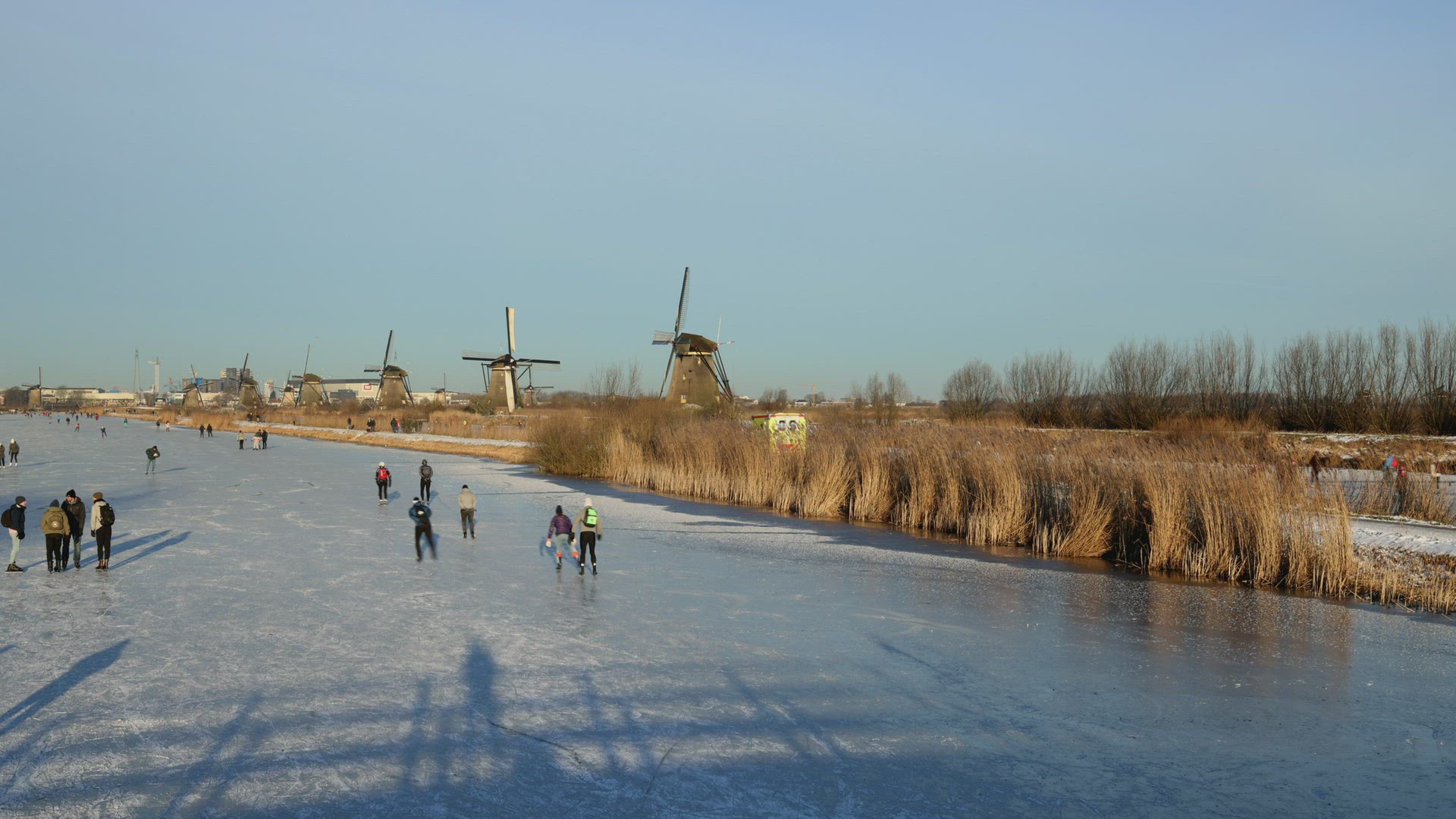 People ice skating on frozen river, Kinderdijk, Netherlands