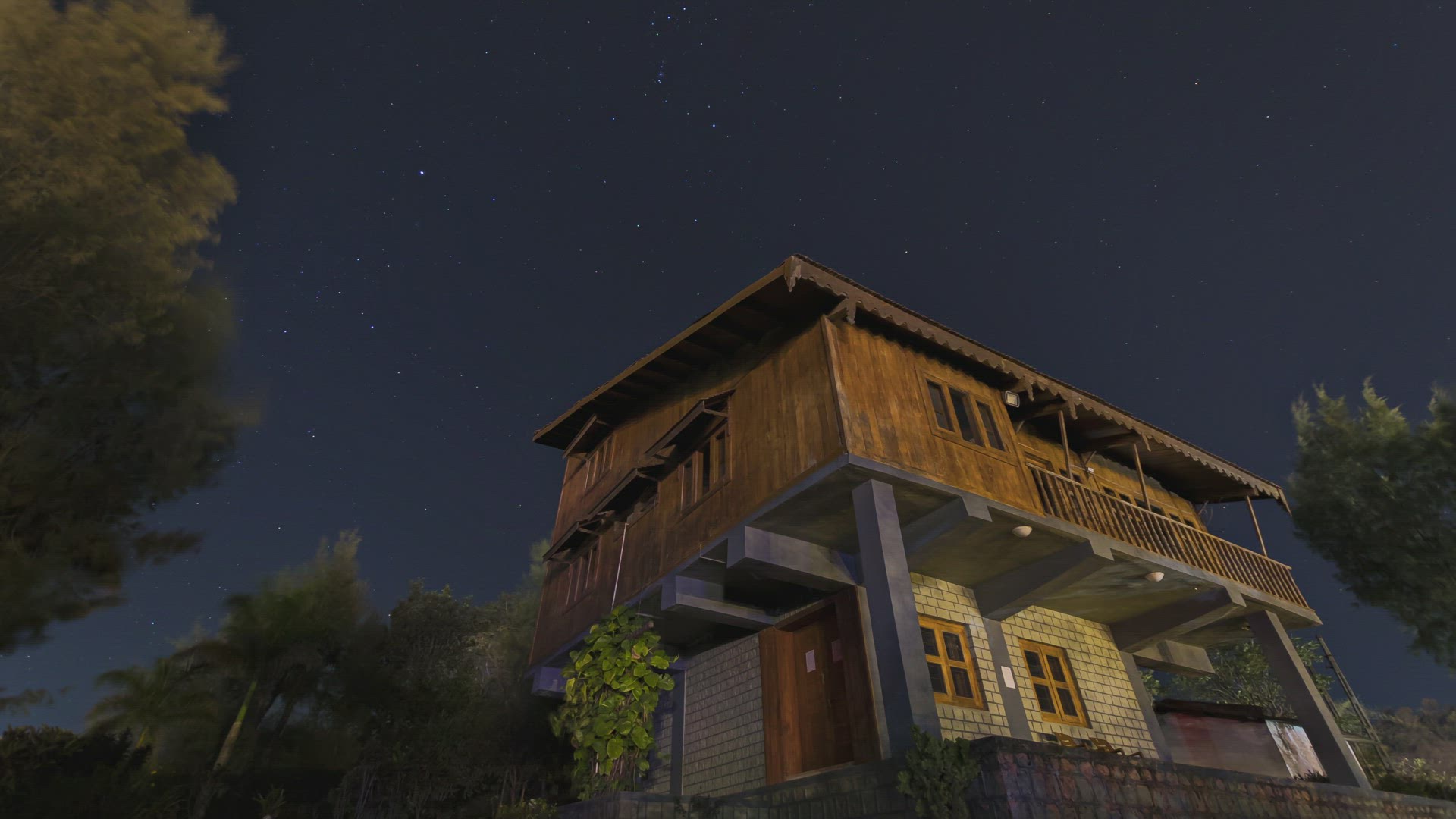 A lone farm house in Forest and Time Lapse of stars moving on a clear night sky, India