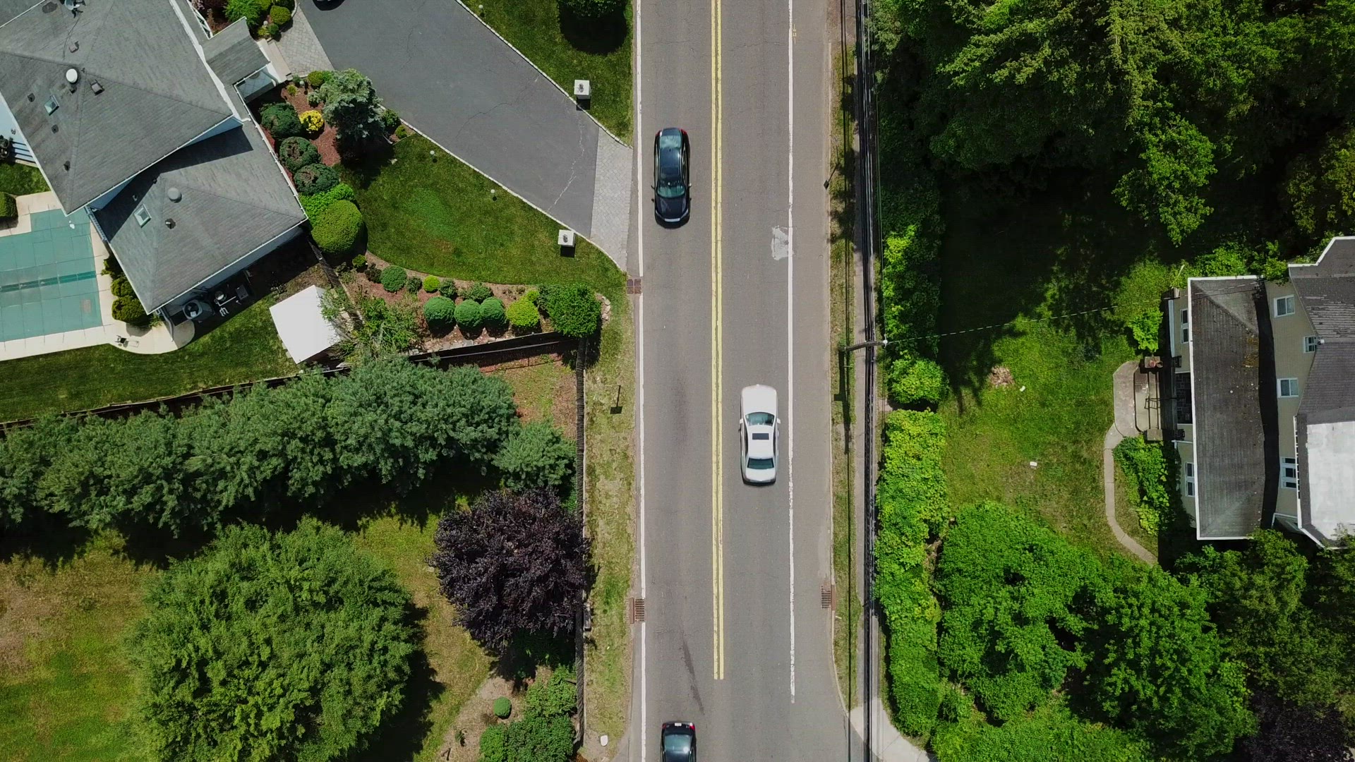Bird's Eye Camera Tilt View of Moving Cars on a Suburban Country Road