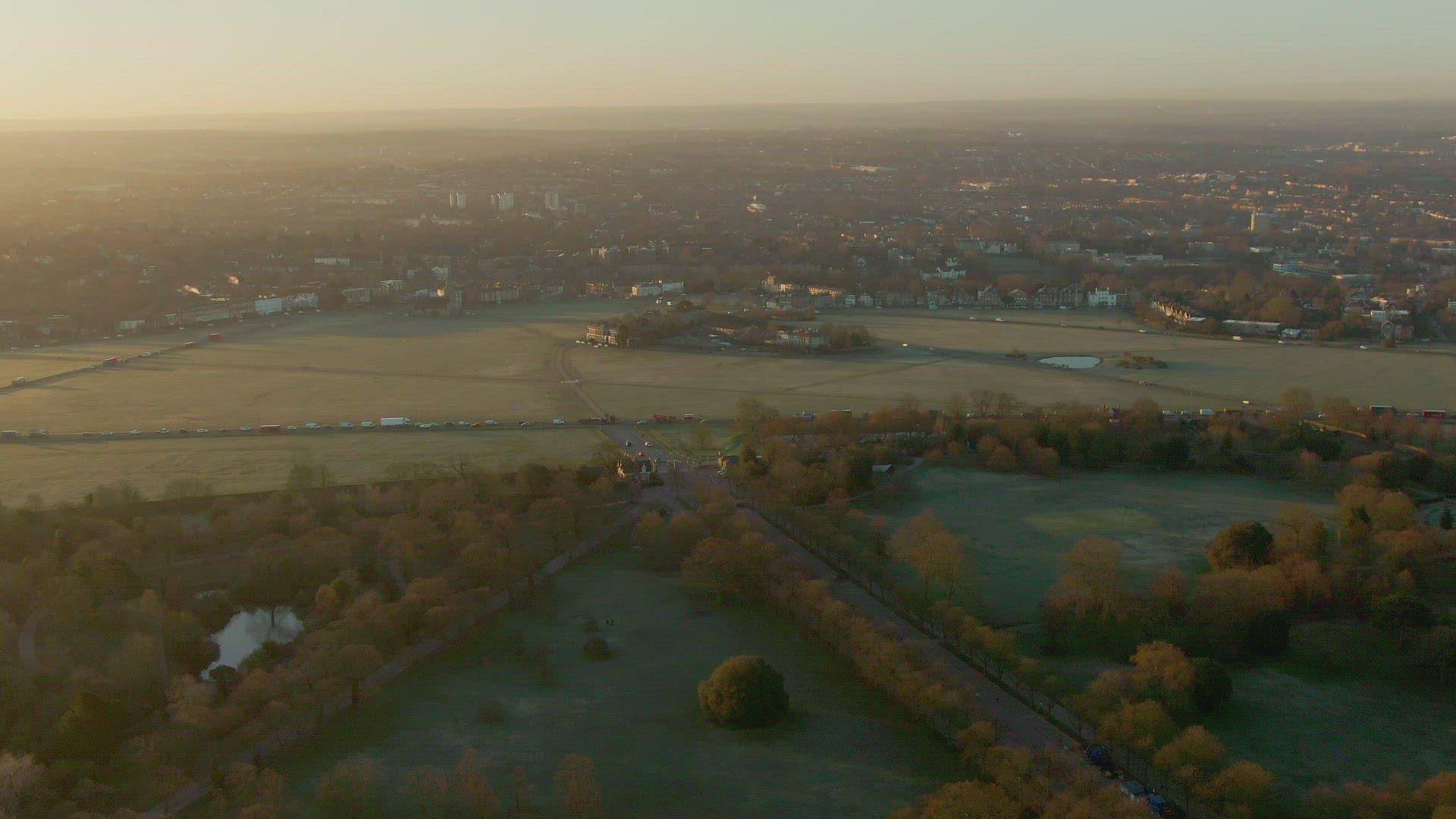 traffic on roads crossing fields at sunset, London, UK