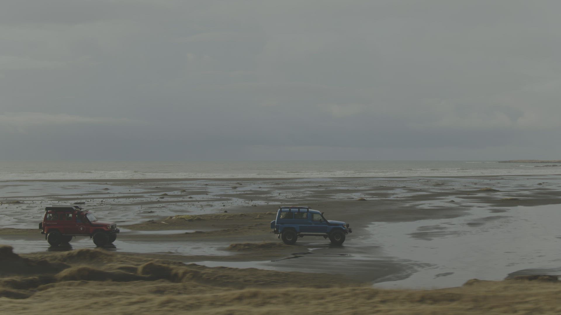 Colorful trucks driving along beach