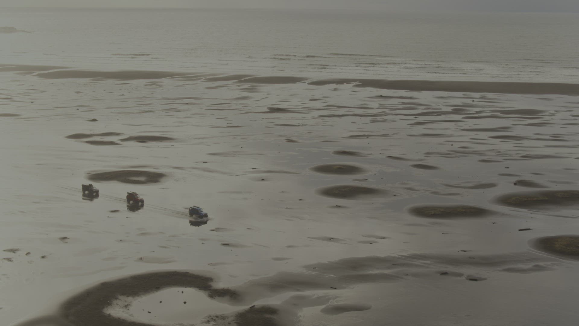 Trucks driving along beach