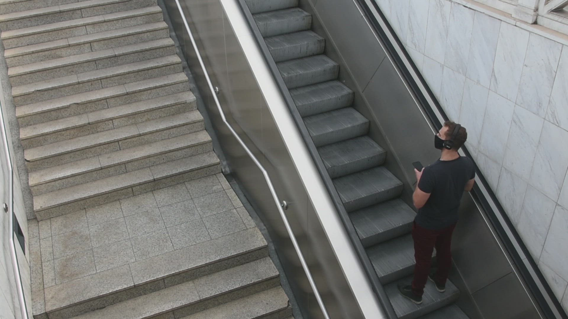 young man while climbs the metro station stairs  wearing protective mask