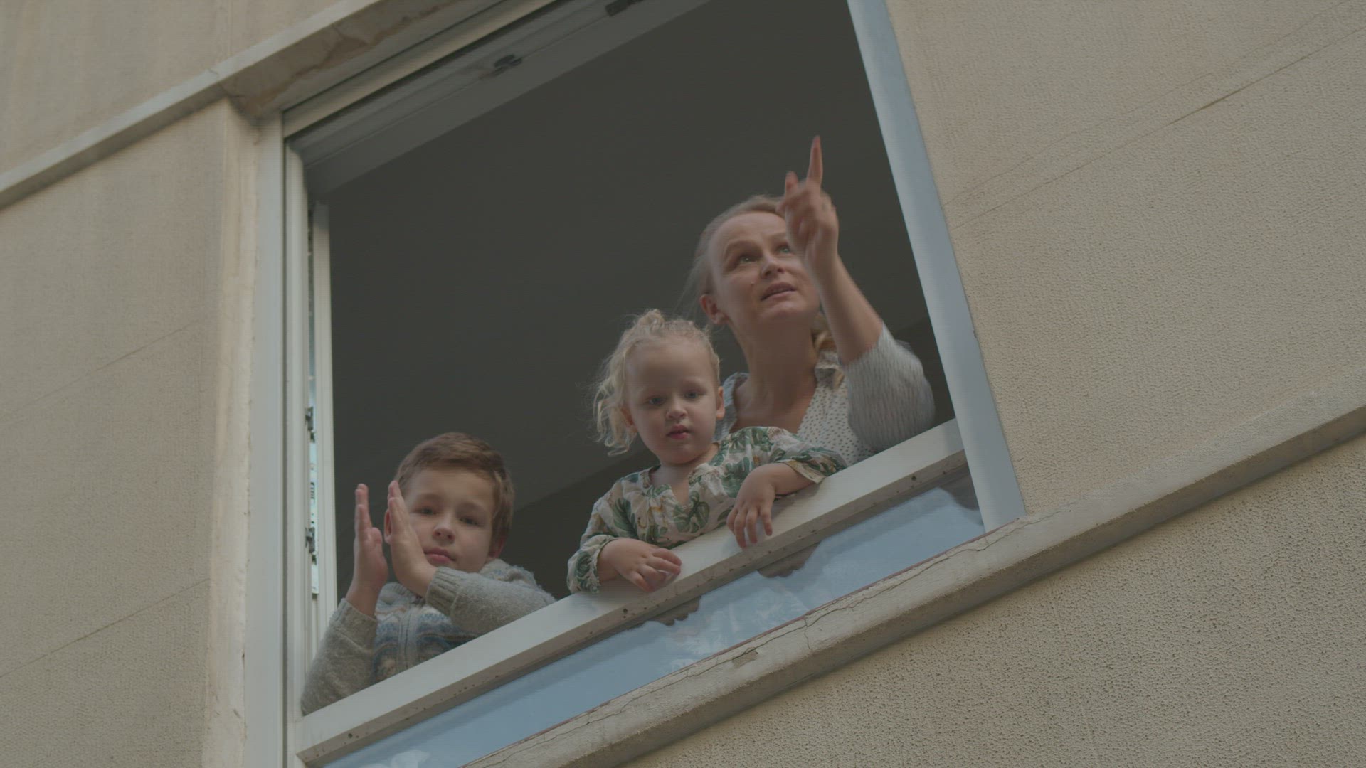 Family in open window during Covid-19 quarantine