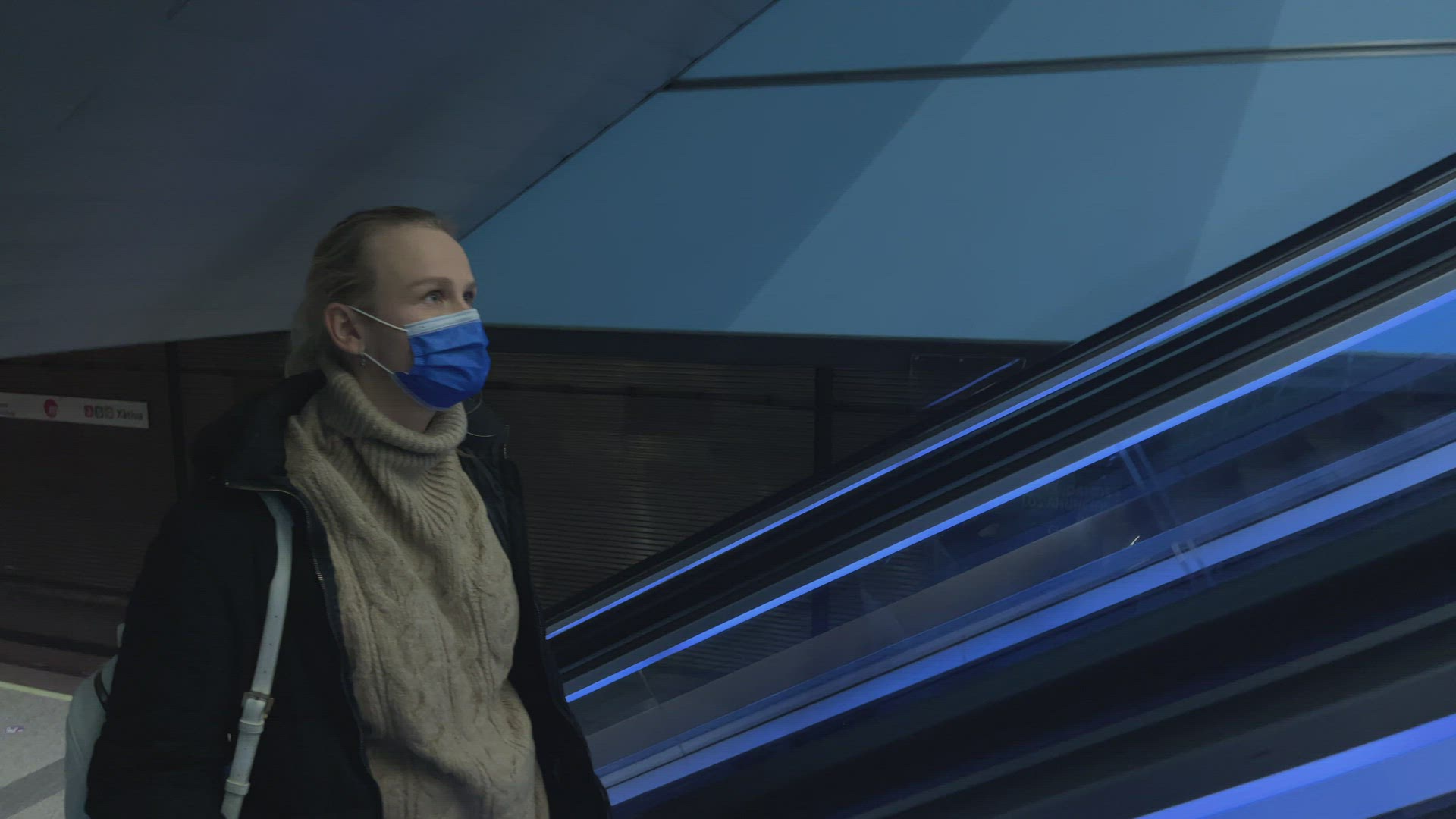 Commuter in medical mask on escalator in subway
