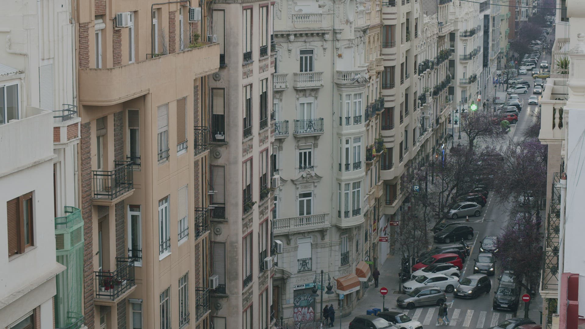 Street of Valencia with residential buildings and many parked cars, Spain