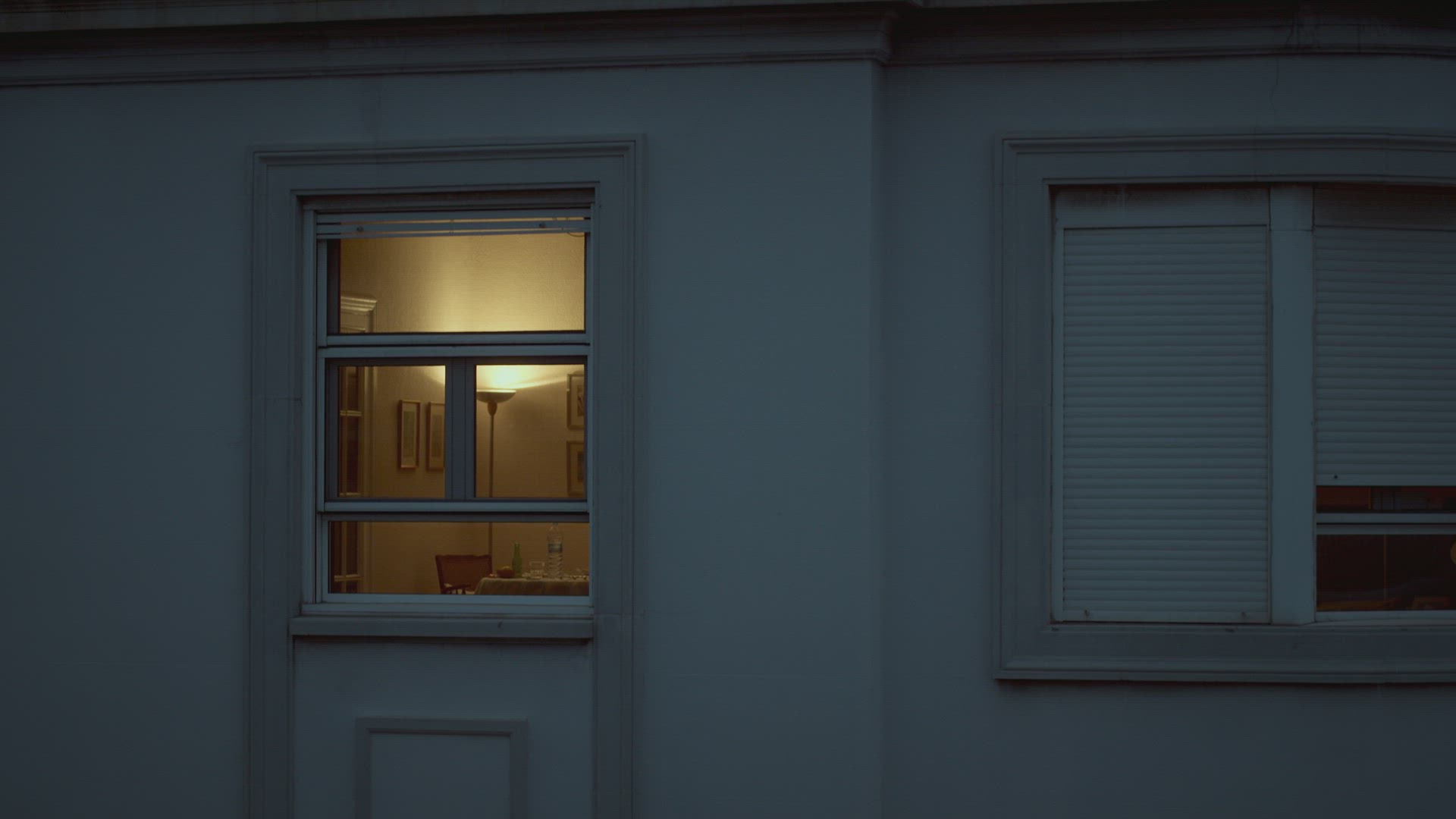 House window with dim light in the dusk
