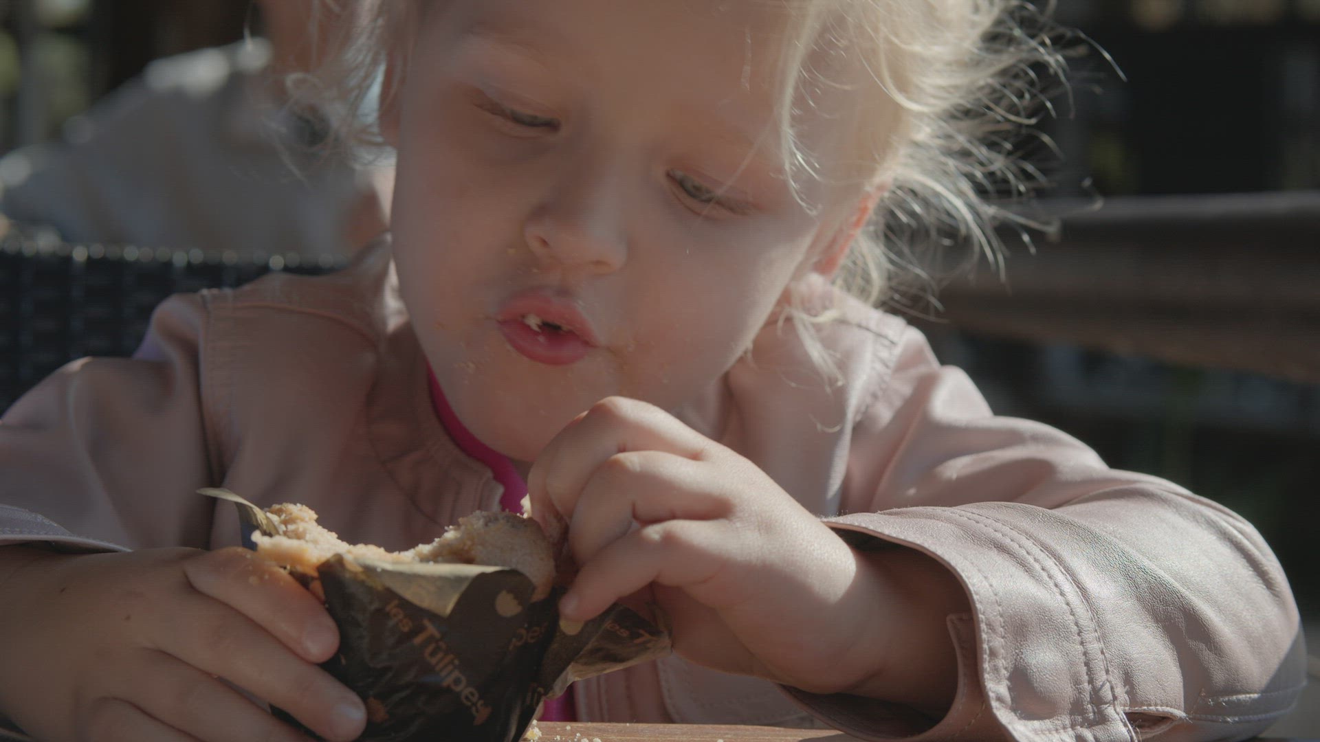 Kid eating sweet bun on street