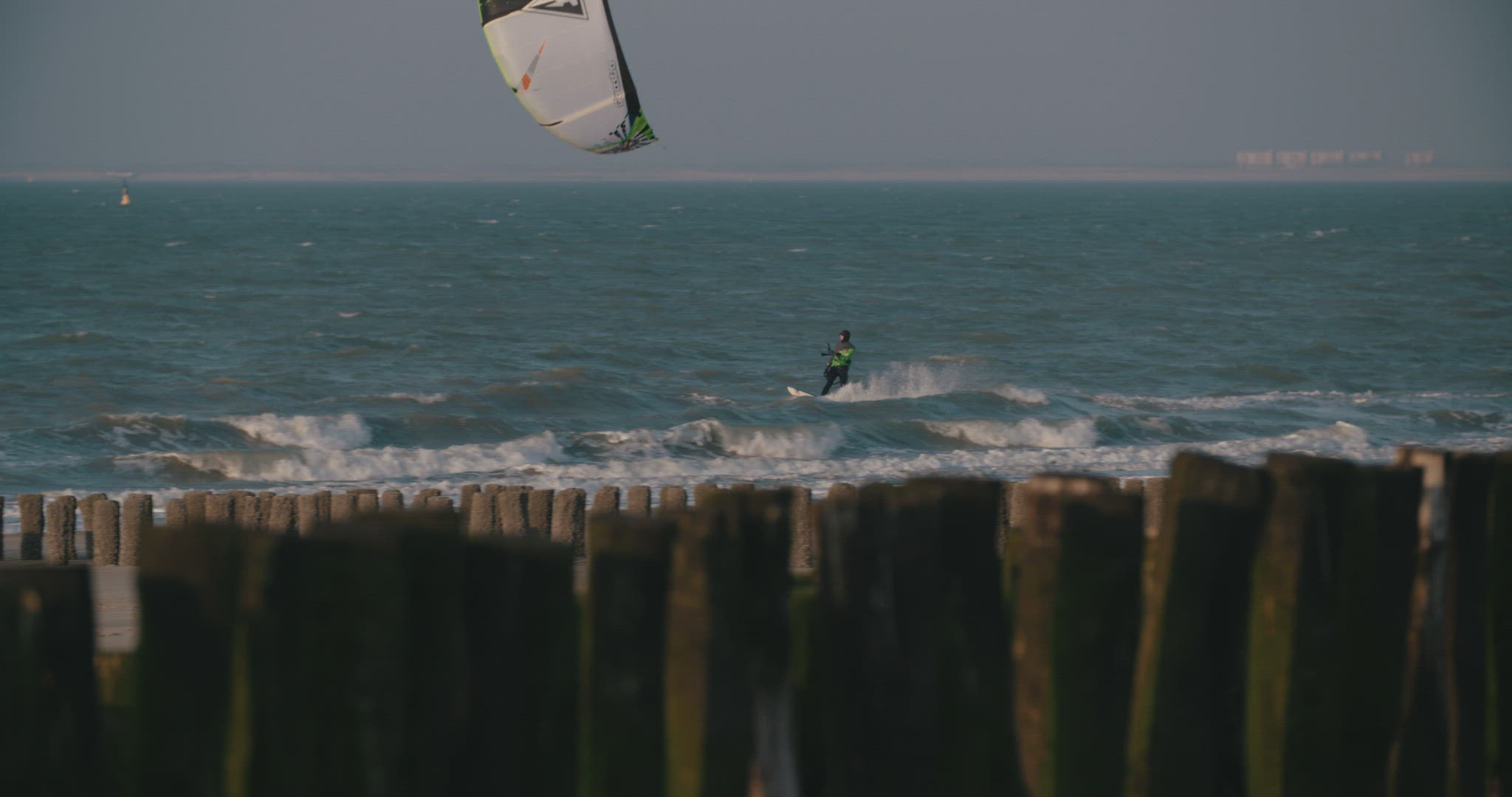 kitesurfer beach mediumshot wood pines 4k
