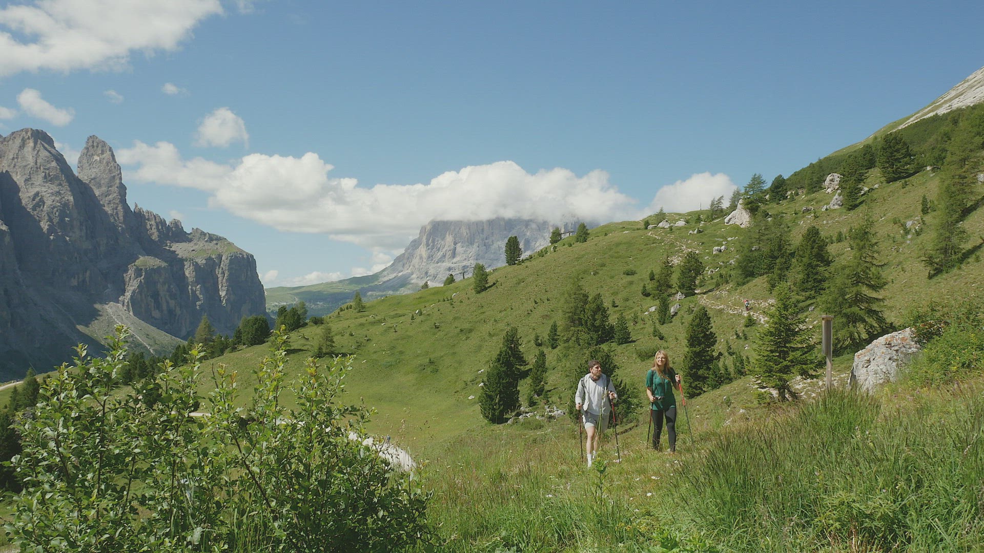Two people hiking in mountain landscape, Alta Badia, Italy