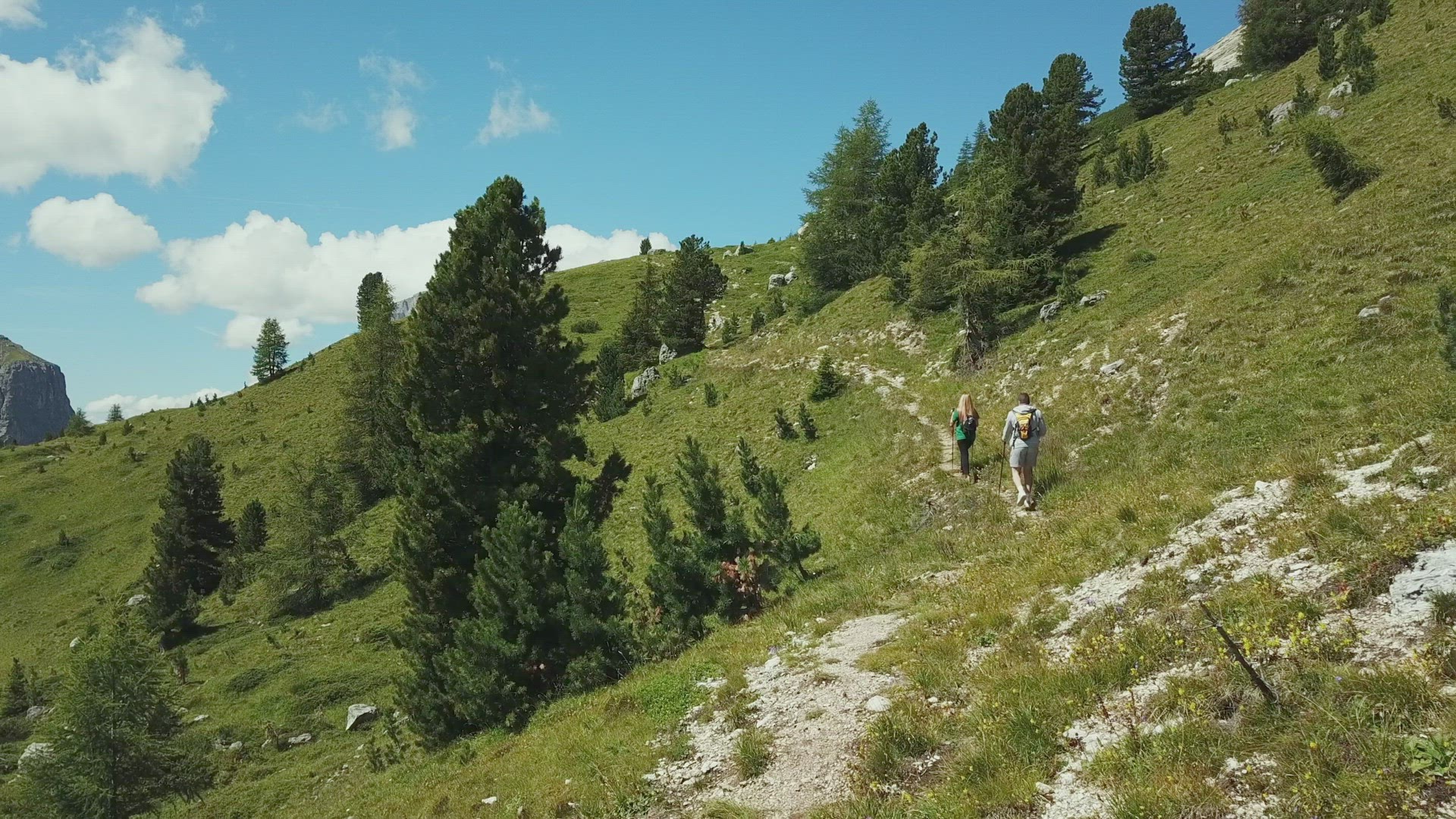 Man and woman hiking in mountain landscape, Alta Badia, Italy