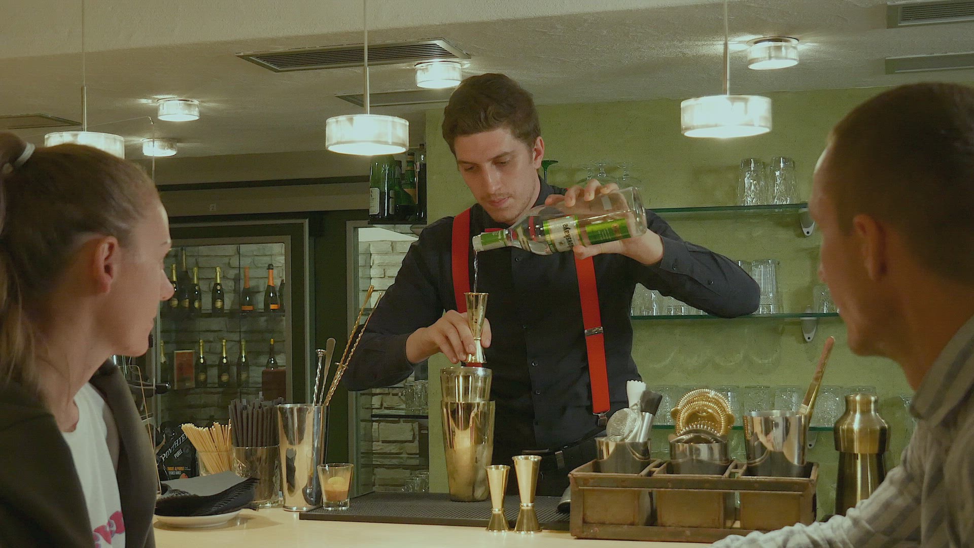 Bartender preparing cocktails for couple at bar counter, Alta Badia, Italy