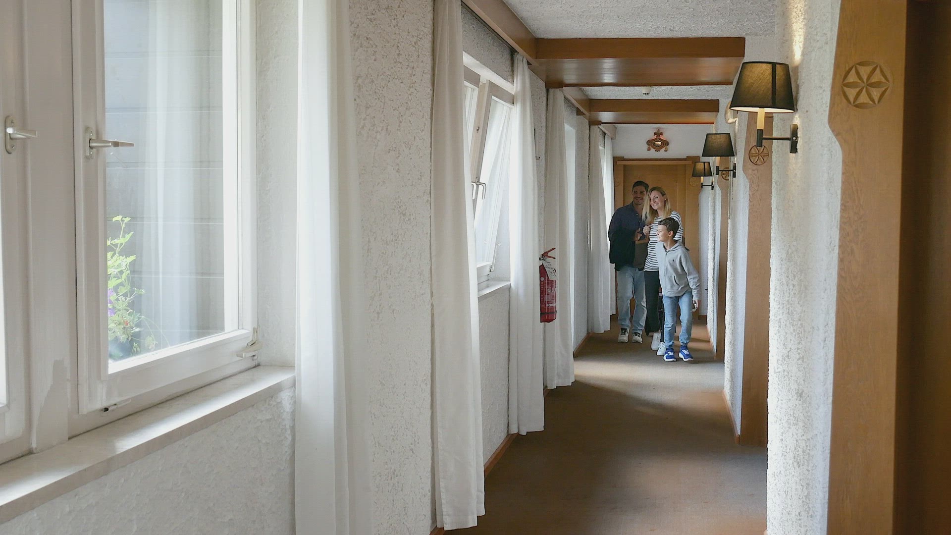 Family with son (8-9) walking in hotel corridor, Alta Badia, Italy
