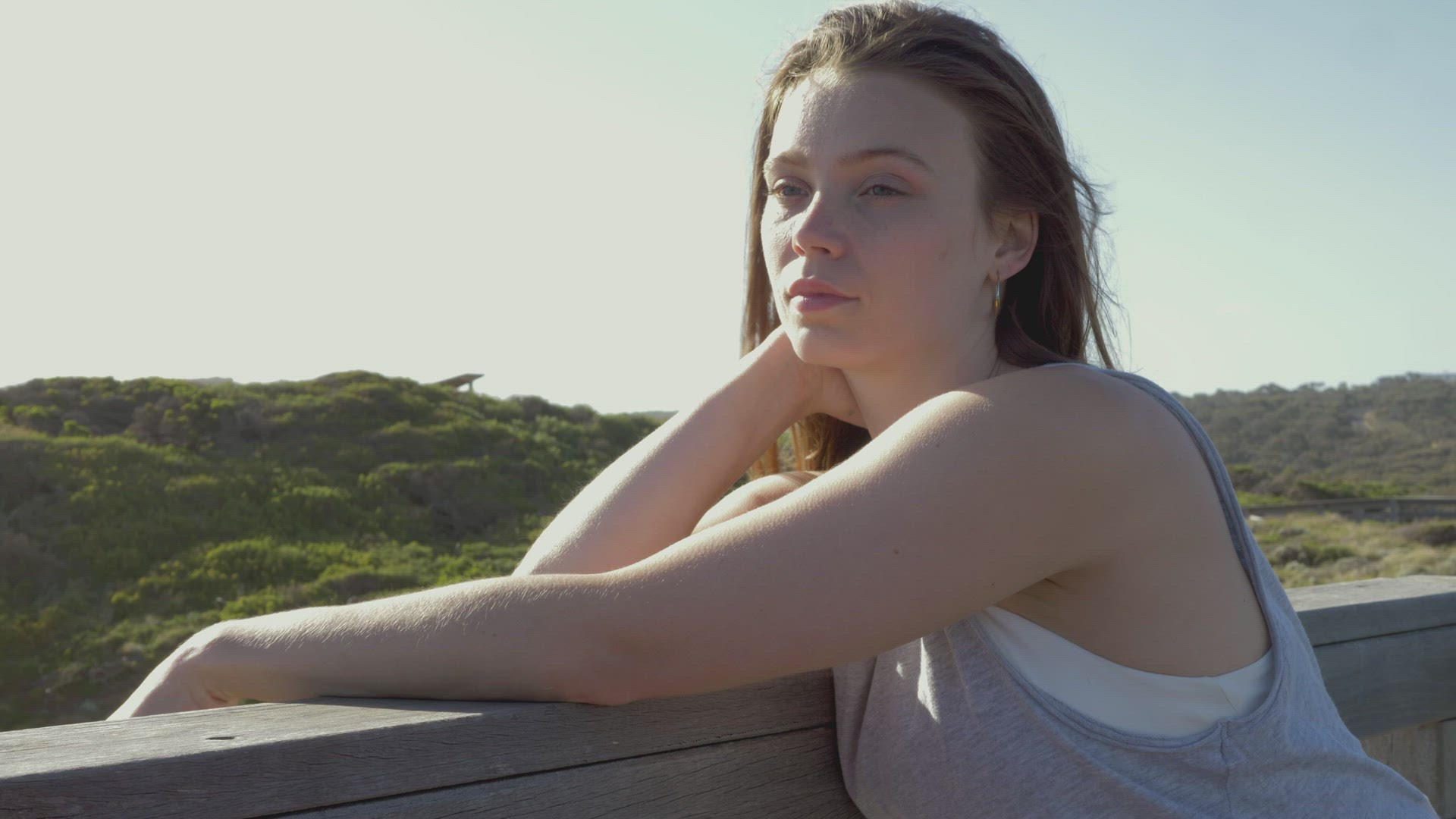 Portrait of woman leaning on fence in landscape, Victoria , Australia