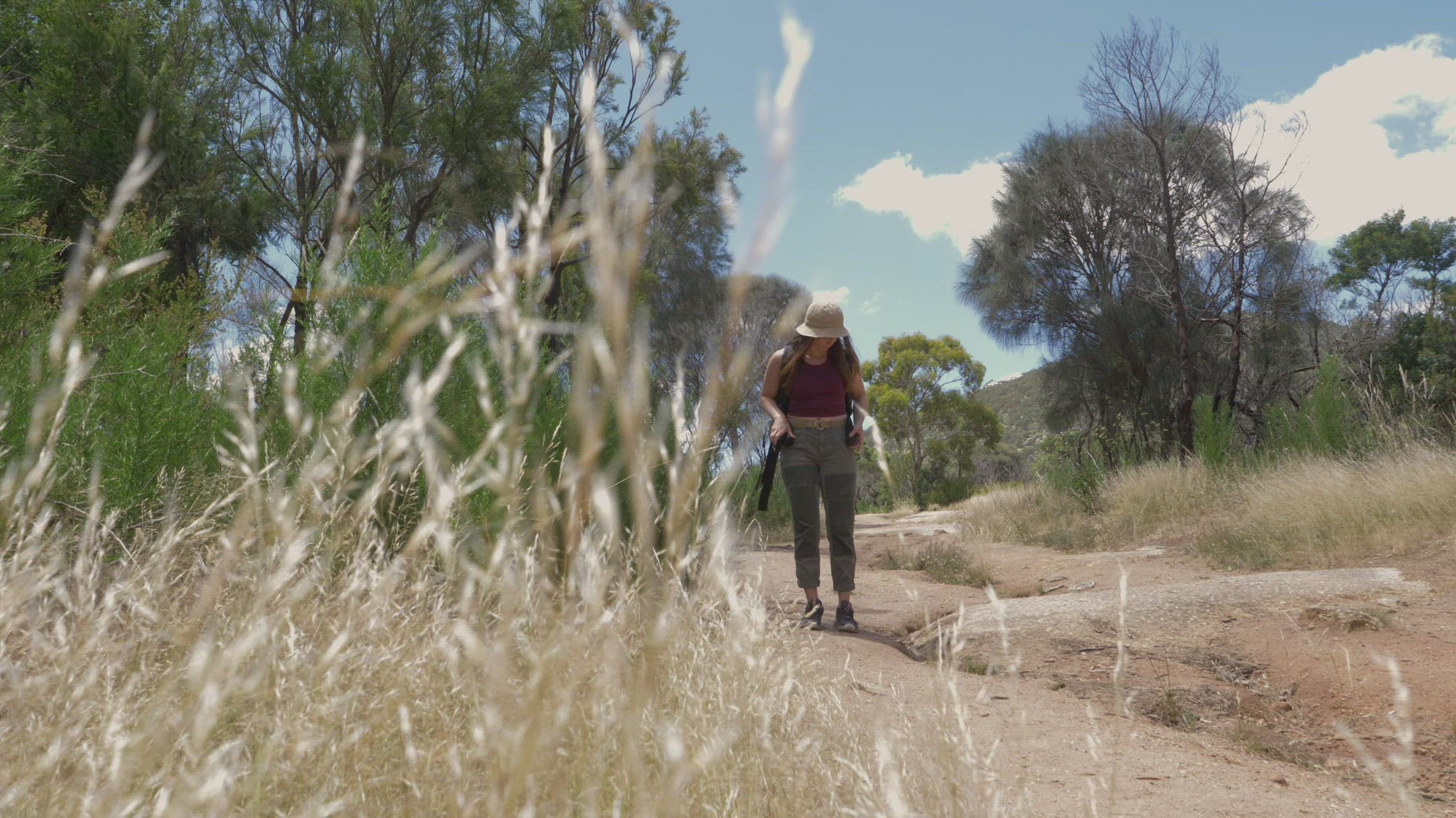 Woman with backpack on footpath in landscape, Victoria, Australia