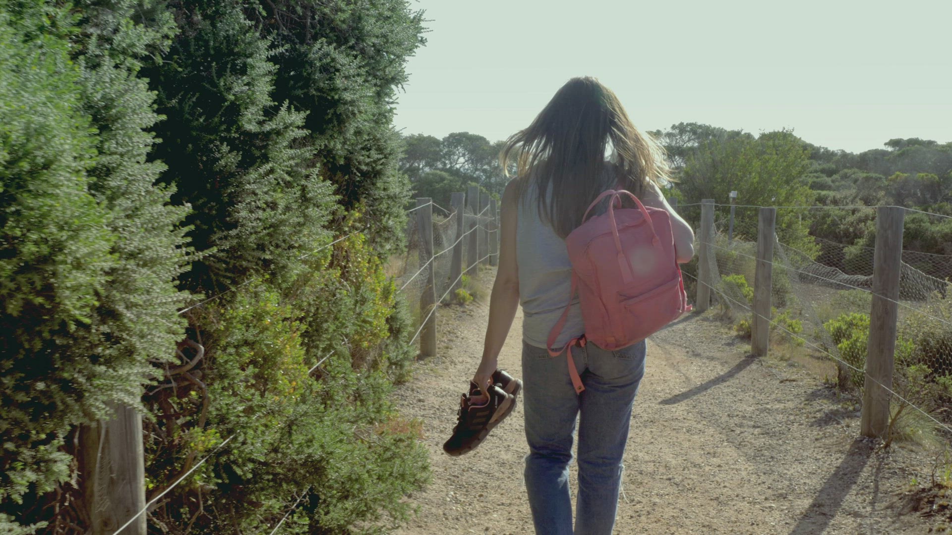 Rear view of young woman walking on footpath, Victoria , Australia