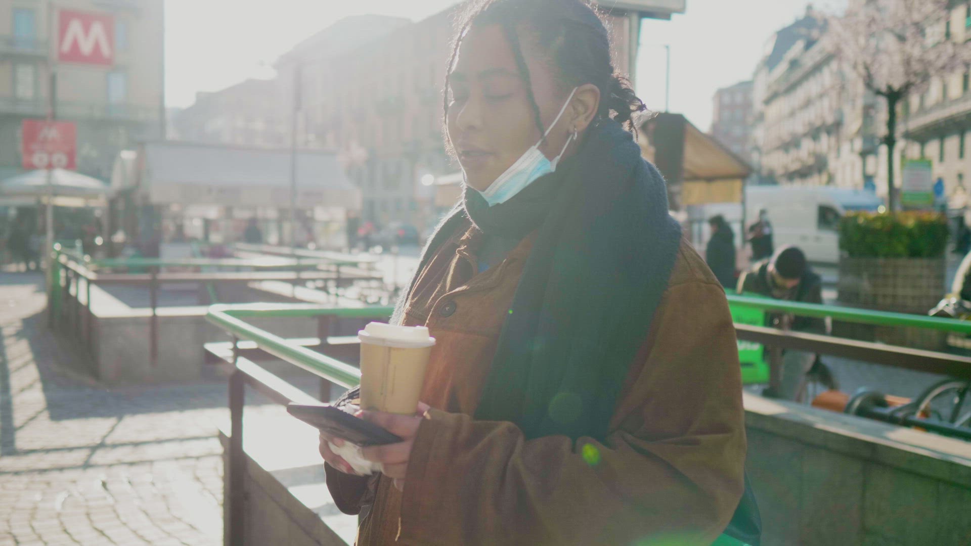 Young woman with face mask using smart phone outdoors, Italy