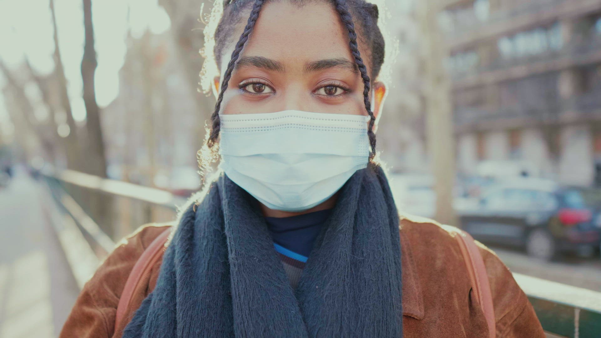 Portrait of young woman removing face mask and smiling outdoors, Italy