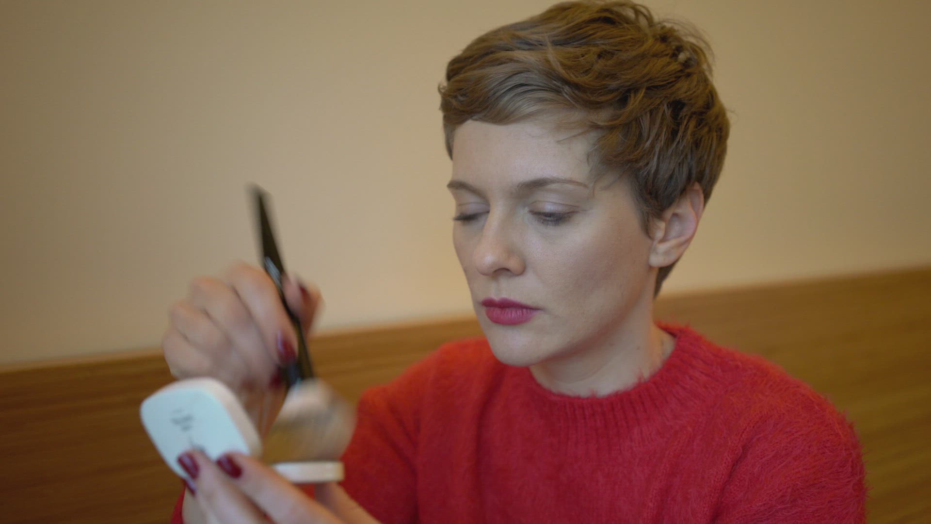 Woman applying make-up at home, Berlin, Germany