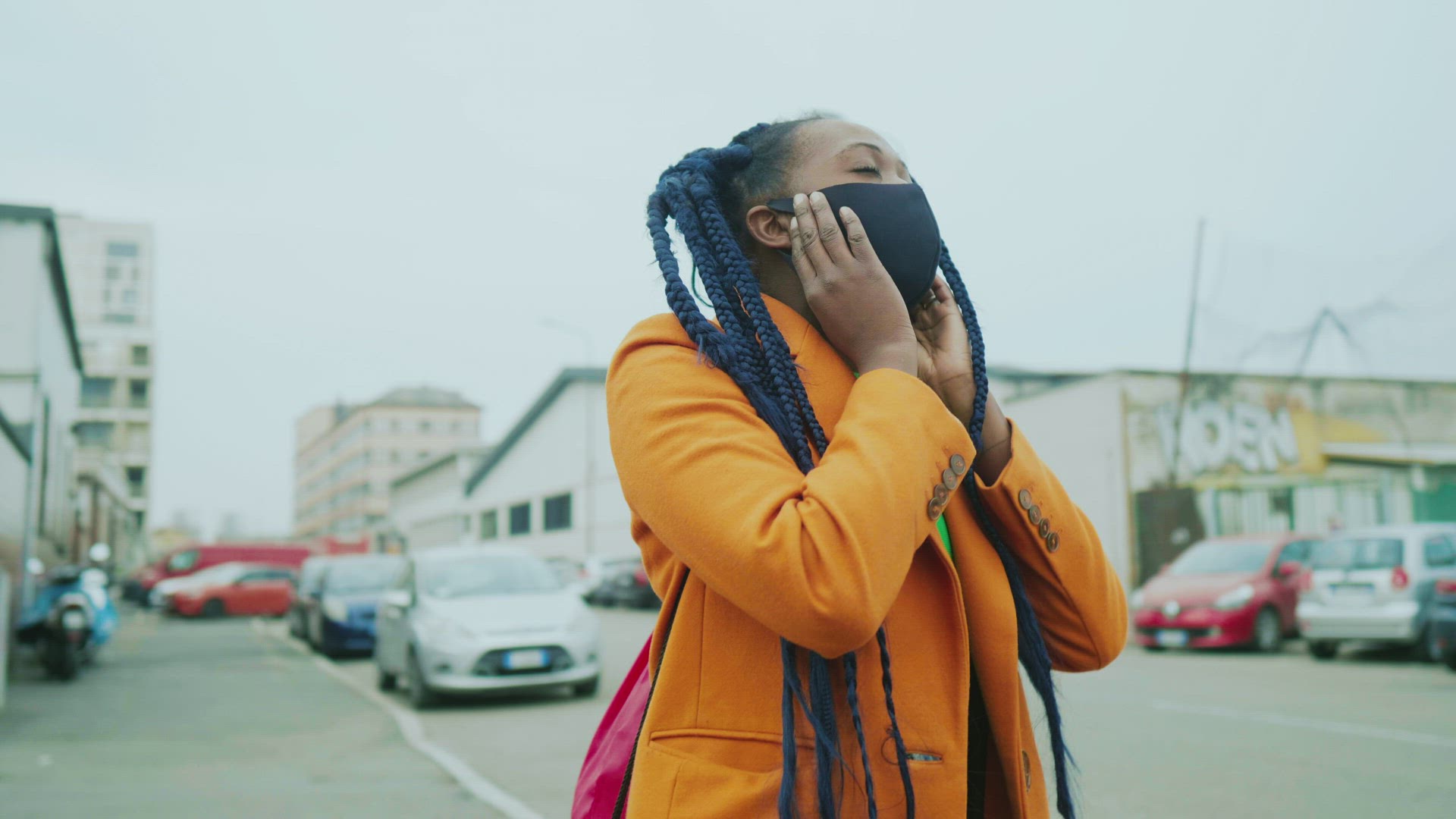 Woman with long black braids removing face mask in city, Milan, Italy
