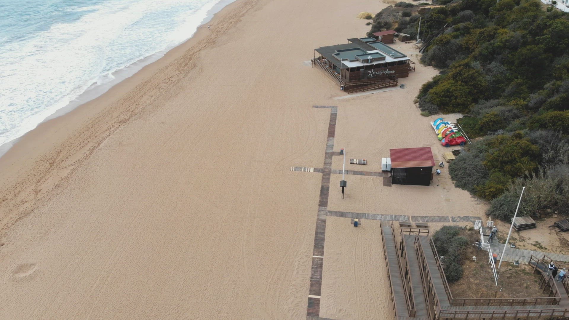 4k aerial drone footage following a coastline sandy beach and tilt revealing the popular European re