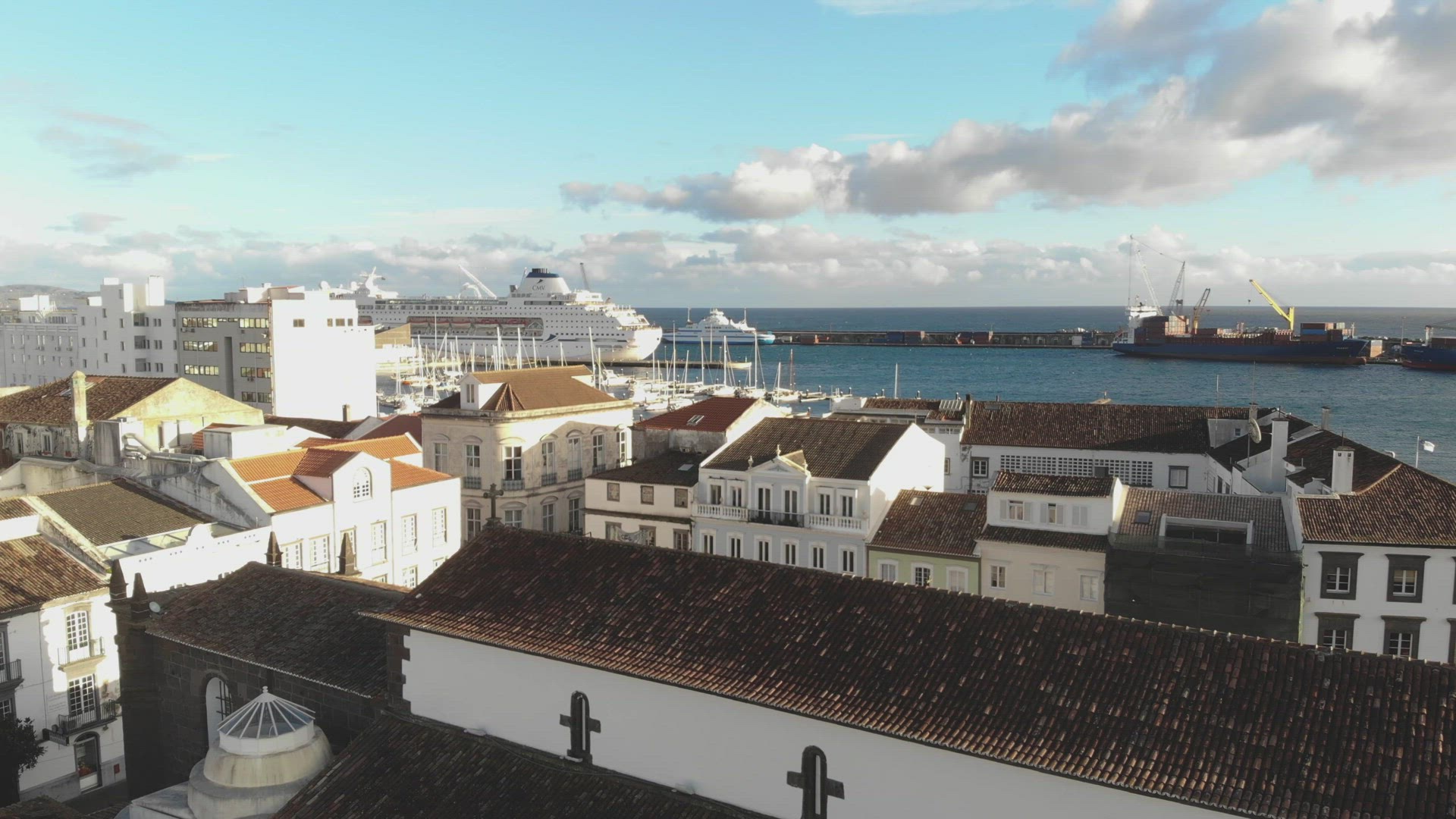 Aerial view of seaside houses with cruise ship parked off Ponta Delgada, Azores.	